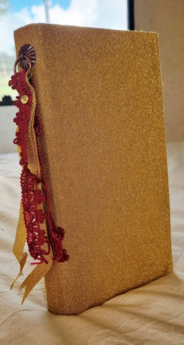 Carnet artisanal fait main avec couverture en tissu doré et marque-page décoratif.